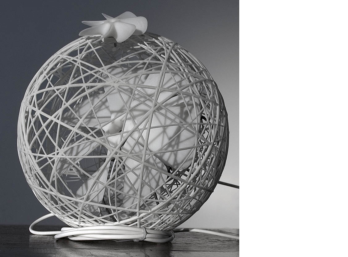 A ball shaped desk fan with a small windmill on the outside of the fans mesh.