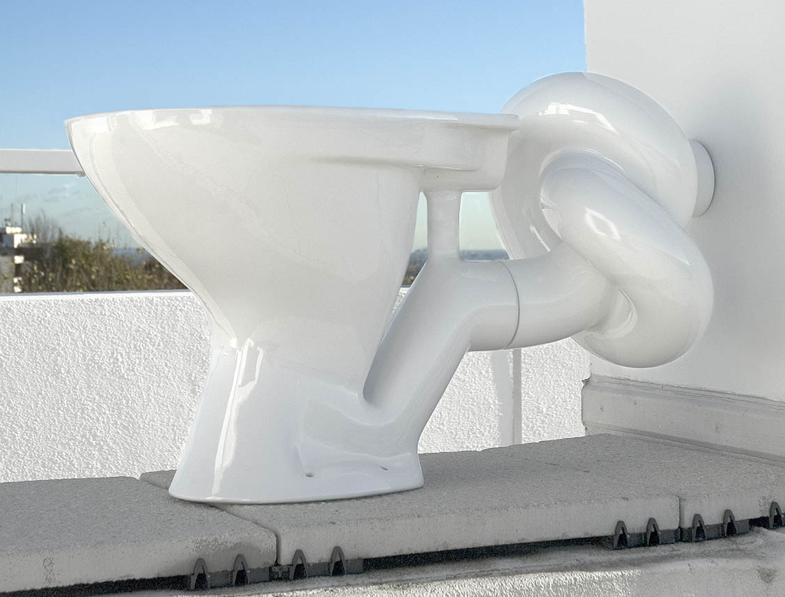 A toilet with an outflow pipe in the shape of a large knot