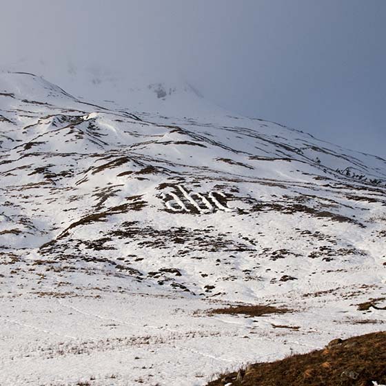 Melt by Michael Cross. Giant letters acb made of smow on a hillside.